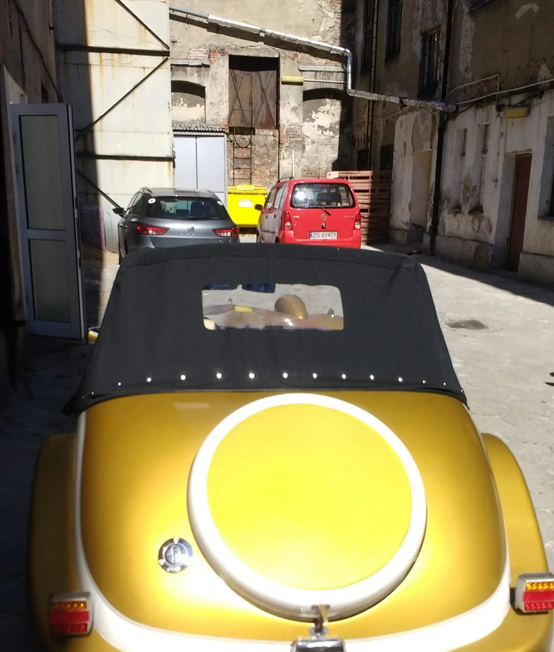 żółty samochód przykryty plandeką